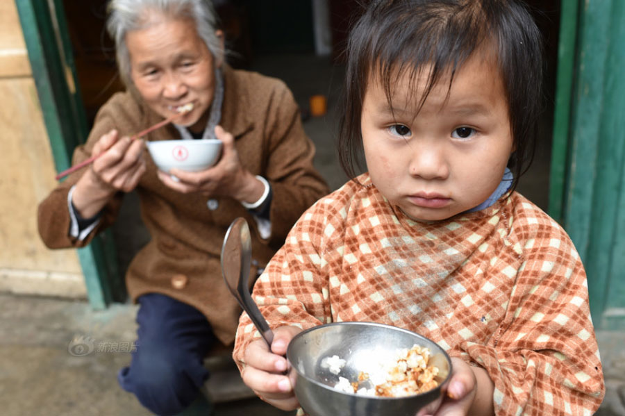 Huang Huiying and her granddaughter eat a meal cooked using only rice and soy sauce. [Photo/Sina]
