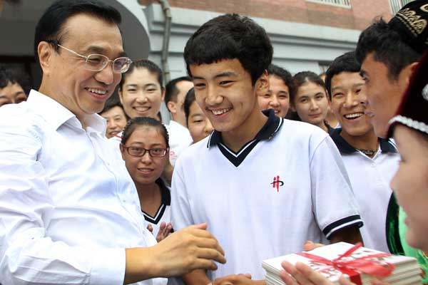 Premier Li Keqiang talks with Xinjiang students at Dalian No 20 Senior High School in Liaoning Province on Monday, one day before Teachers' Day.