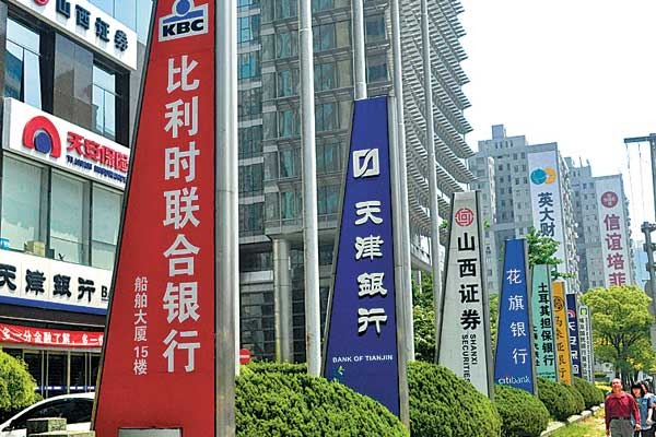 Banners and advertisements of Chinese and foreign financial institutions in Shanghai. The planned pilot free trade zone in the city is attracting major foreign banks to set up branches there for a wider range of yuan businesses.