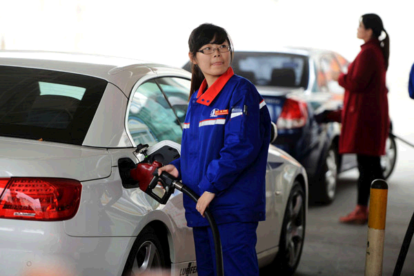 An employee refuels a vehicle at a gas station in Qingdao, Shandong Province on Oct 31.