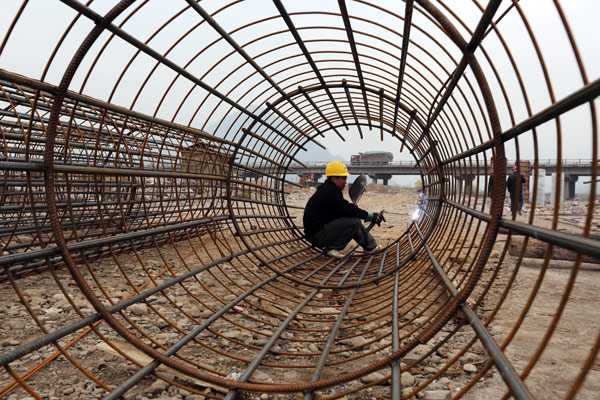 A worker welds a steel frame for a bridge under construction in Linzhou, Henan Province. The National Development and Reform Commission is expected to work out an annual target list to implement reform initiatives mapped out at a key leadership meeting earlier this month.