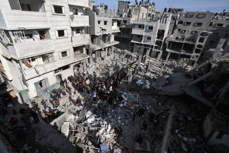 Palestinians inspect the rubble of a destroyed building following the Israeli military operations in Gaza City on January 14, 2009. [Xinhua]