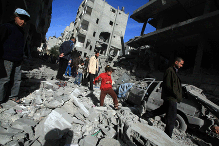 Palestinians inspect the rubble of a destroyed building following the Israeli military operations in Gaza City on January 14, 2009. [Xinhua] 