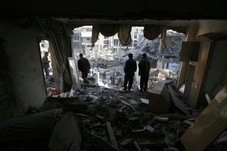 Palestinians inspect the rubble of a destroyed building following the Israeli military operations in Gaza City on January 14, 2009.[Xinhua]