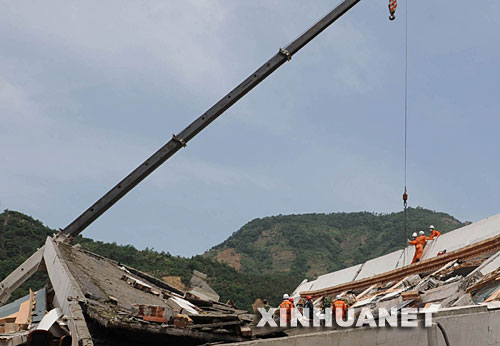 　5月18日，救援队员在北川县城的废墟中搜救。当日，在汶川地震重灾区北川，解放军、武警官兵和预备役救援人员一起冒着危险，继续在废墟里搜救并进行清理工作。