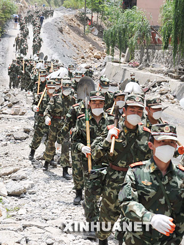 5月18日，武警某部官兵奔赴北川县城搜救。当日，在汶川地震重灾区北川，解放军、武警官兵和预备役救援人员一起冒着危险，继续在废墟里搜救并进行清理工作。