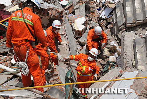 5月18日，一名救援队员在北川县城的废墟中搜救。当日，在汶川地震重灾区北川，解放军、武警官兵和预备役救援人员一起冒着危险，继续在废墟里搜救并进行清理工作。