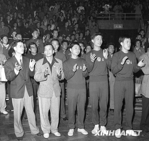 1961年4月9日，中国男子乒乓球队在北京举行的第26届世界乒乓球锦标赛男子团体比赛中首次夺得世界男子团体冠军。这是赢得男子团体冠军的中国男子乒乓球队的教练和运动员在场上鼓掌庆贺胜利。