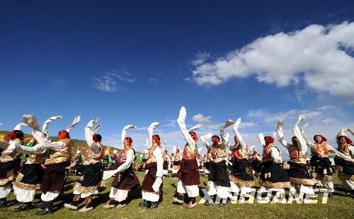  8月4日，藏北牧民跳锅庄舞。当天，万名藏北牧民身着节日盛装，聚集在那曲草原上，在《草原欢庆迎奥运》和《牧人多快乐》两首乐曲的伴奏下，跳起锅庄舞，迎接北京奥运会的到来。 新华社记者 觉果 摄