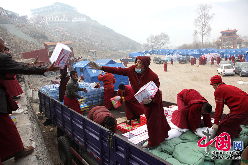 19日是玉树地震第5天，全国各地救灾、救援、捐献物资的队伍源源不断陆续开进灾区。当前，玉树灾区当务之急是继续寻找生存者，救治外运伤病员，解决群众衣食住问题，即灾区群众要有饭吃，有帐篷住，有饮用水喝。这是僧人们在搬运捐赠物资。 成为东/摄影