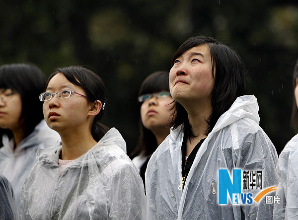 4月21日，复旦大学的学生们在雨中参加降半旗仪式。