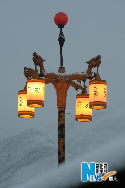  这是玉树地震灾区结古镇，在雪中点亮的印有藏文的路灯（4月21日摄）。 