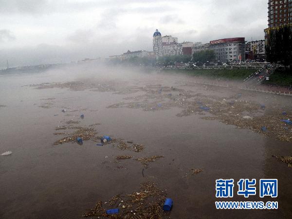 这是7月28日拍摄的漂浮在松花江中的化工厂原料桶