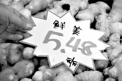 山东省临沂市郯城县一家超市的员工将当日的价格牌放在生姜上。