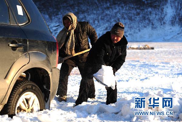 11月28日，在科右前旗满族屯满族乡，几名群众设法将陷入厚厚积雪中的越野车弄出来。
