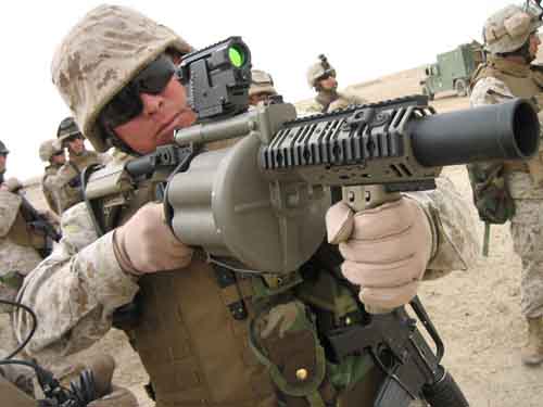 身着沙漠ACU作战服、防弹背心、手持半自动榴弹反射器的美军士兵。
