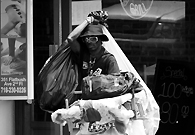 纽约哈莱姆区街头一个流浪汉背着他收来的垃圾。