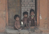 孩子们坐在家门前，没有衣服穿，光着身子。