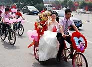 5月30日，在江西南昌文教路上，一位新郎用三轮车迎娶新娘。当日，在江西南昌街头，一对新人采用三轮车、自行车等低碳环保的交通工具举行婚礼，以实际行动迎接今年6月5日第39个世界环境日的到来。（中新网）