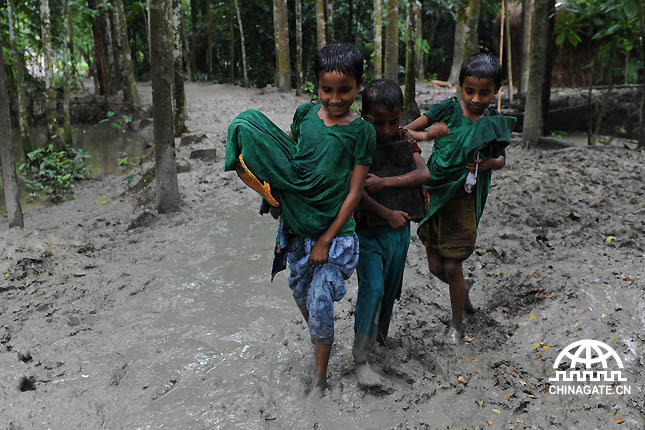 孩子们冒着雨，踏着泥泞去上学。