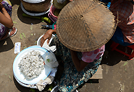 时值宝塔节，一些村民在马德亚镇集市上卖自制的食品。他们没钱支付门脸费或者摊位费，只能席地而坐，把东西放在地上。
