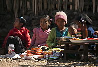 那加的一个传统节日期间，一些小孩坐在地上，帮家里人卖东西，他们卖的货物有零食，饮料，还有当地人自己做的玩具小熊。