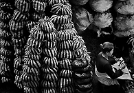 一个卖木炭的小贩在数今天挣了多少钱。20000印度尼西亚盾约合人民币13元。