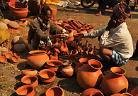 做小本买卖的商贩在根杜里的露天市场卖自制的陶壶。