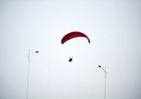 10月25日下午,動力傘從一對路燈上空飛過。本報記者陳杰攝