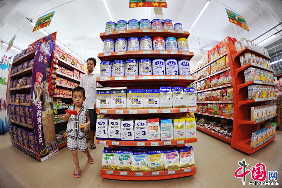2013年7月10日，海南琼海消费者从一家超市奶粉专柜旁经过。 中国网图片库 蒙钟德摄影