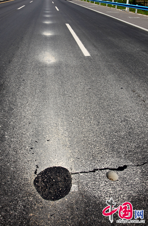 2013年8月11日，河南省滑县县城至大广高速公路快速通道，该快速通道建成不到一年时间，已有多处路面损毁、修补。 中国网图片库 王子瑞摄影