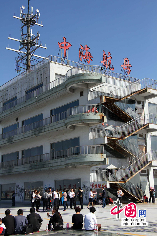 2013年10月2日，山东滨州，游客在投资1.2亿元的“水泥疙瘩”中海航母上游玩。国庆长假期间，平日里无人光顾的山东滨州中海航母迎来大量各地猎奇游客，一睹这座投资1.2亿元的“水泥疙瘩”真面目。