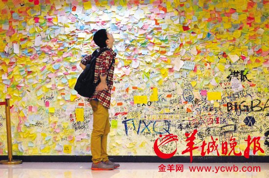 ▲2013年“光棍節”來臨，廣州的單身男女們在千方百計尋找自己的叧一半。圖為在廣州某商場內，這位男生在真情留言墻上尋找著什么？
