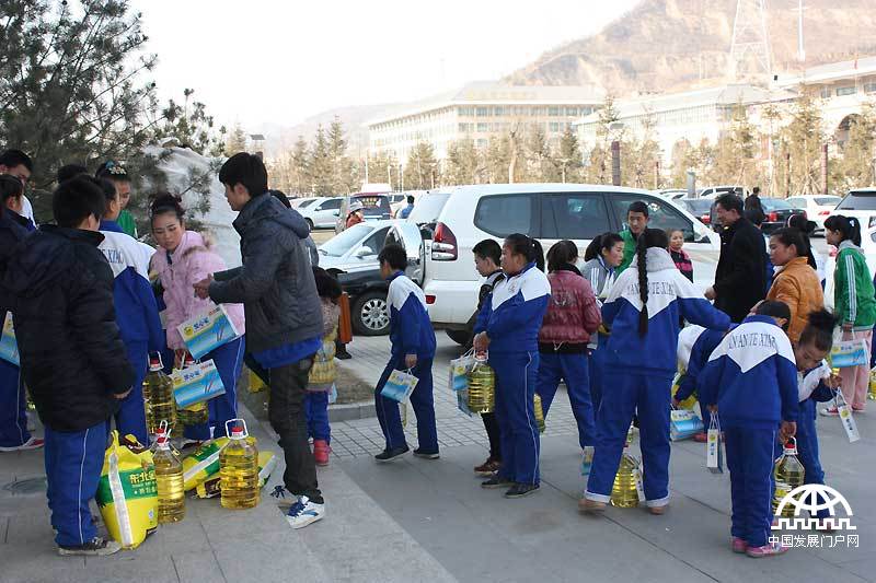 12月21日，中国首善、全国道德模范陈光标携百名企业家走进革命圣地延安，开展了“感恩延安行”活动。他们一起给1000多名延安老区的困难群众和贫困学生发红包、大米和食用油。中国发展门户网 王振红拍摄