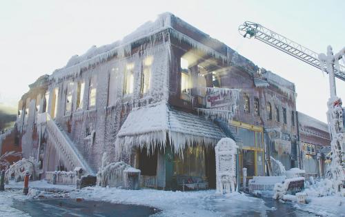 美国中东部地区连日遭受暴风雪袭击。图为美国普拉茨茅斯一处失火大楼在消防水枪喷洒后结上厚冰。