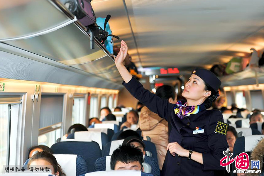 巡視車廂內貨架上旅客物品是否排放安全，是每次發車前的必要工作。中國網圖片庫 徐暉銘/攝