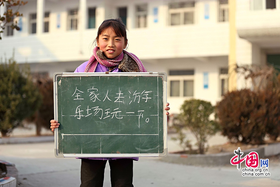 2013年1月14日，安徽省蚌埠市固镇县清凉小学，六年级学生在寒假即将来临前，展示寒冬里的假期心愿。图为蔡丽佳，寒假愿望是全家人去游乐场玩一下。