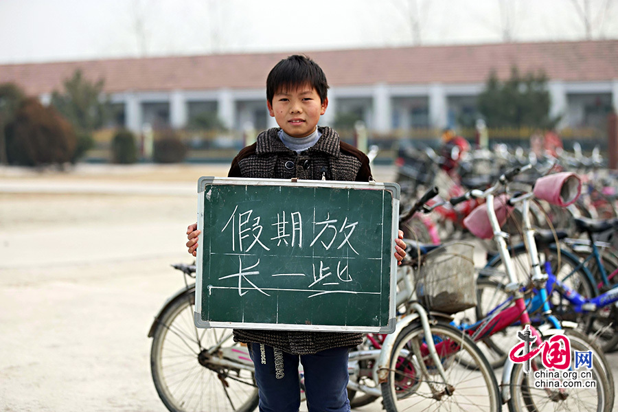 2013年1月14日，安徽省蚌埠市固镇县清凉小学，六年级学生在寒假即将来临前，展示寒冬里的假期心愿。图为张浪，寒假愿望是假期放长一些。