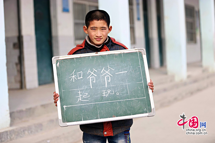 2013年1月14日，安徽省蚌埠市固镇县清凉小学，六年级学生在寒假即将来临前，展示寒冬里的假期心愿。图为邱勤安，寒假愿望是和爷爷一起玩。