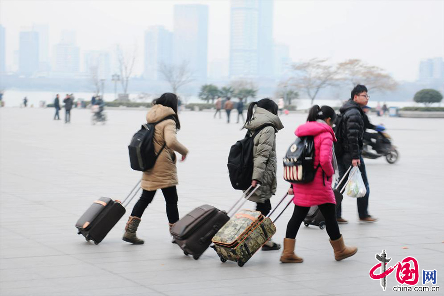  2014年1月16日，南京火车站，几位大学生拖着行李从站前广场转中央门长途汽车站。当天，是2014年全国春运第一天。 中国网图片库 杨素平摄影