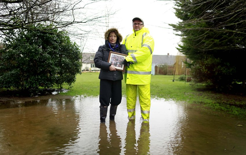 当地时间2014年2月14日，英国Moorland，家庭主妇Jane Clement和丈夫核电站运营经理Paul Clement手持照片合影。照片是他们在洪水来袭时最想的优先挽救的。
