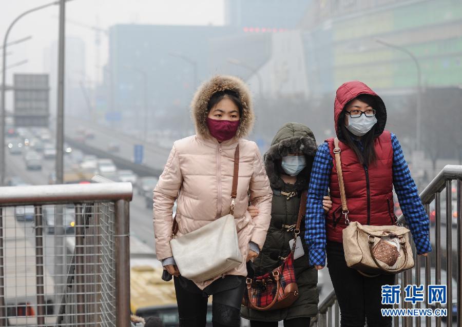 2月20日，几名戴口罩的行人从北京东三环一过街天桥上走过。新华社记者 罗晓光 摄