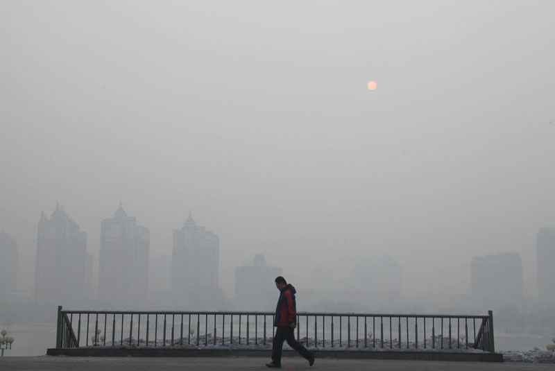 2月25日，一名行人走在雾霾笼罩下的吉林市街头。 新华社发