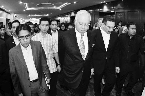 3月24日，马来西亚吉隆坡，马来西亚总理纳吉布（中）离开发布会现场