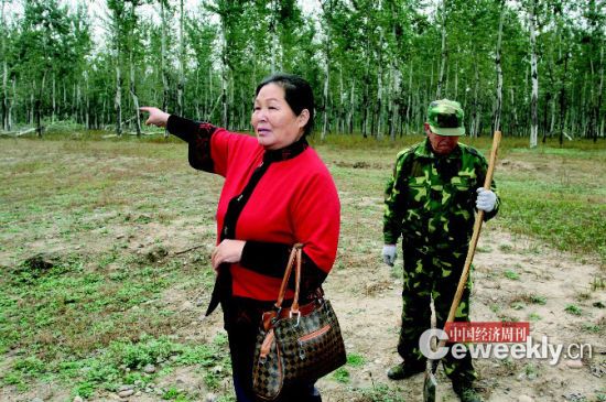 刘玉英，身后是她雇来看护林地的工人 《中国经济周刊》记者 肖翊|摄