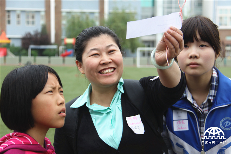 4月19日，来自国际学校和本地学校的根与芽小组同学齐聚北京英国国际学校顺义校区，通过游戏互动，分享了各自的环保活动成果与经验，共同迎接第45个世界地球日的到来。图为“环保知多少”寻宝游戏，学生家长也参与其中。中国发展门户网 杨霄霄拍摄