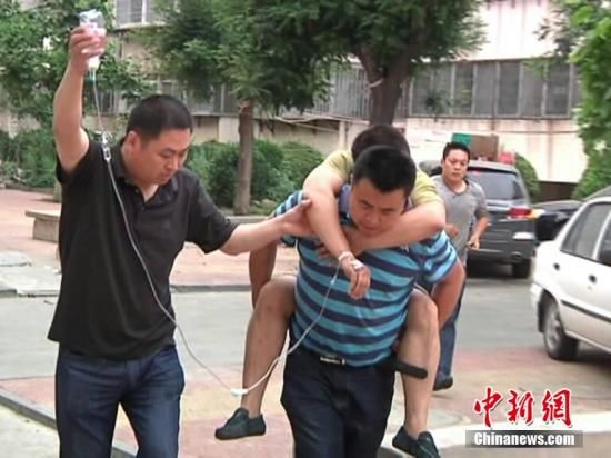 6月1日，招遠“5·28”事件受害者的丈夫被親友從醫院背回家，手上還掛著點滴，他悲痛欲絕，希望嚴懲暴徒。5月28日，6名“全能神教”暴徒在招遠市一家麥當勞餐廳將一名無辜女性殘忍毆打致死。張玉雷 攝
