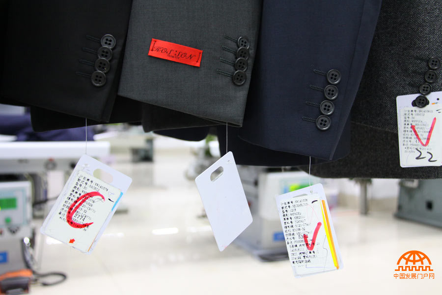 每件个性化定制服装均带有产品信息标签，上面记录着每件服装不同的定制要求。（中国发展门户网 焦梦摄）