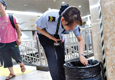 昨日,在地鐵王府井站,安檢員在對垃圾桶進行檢查。新京報記者