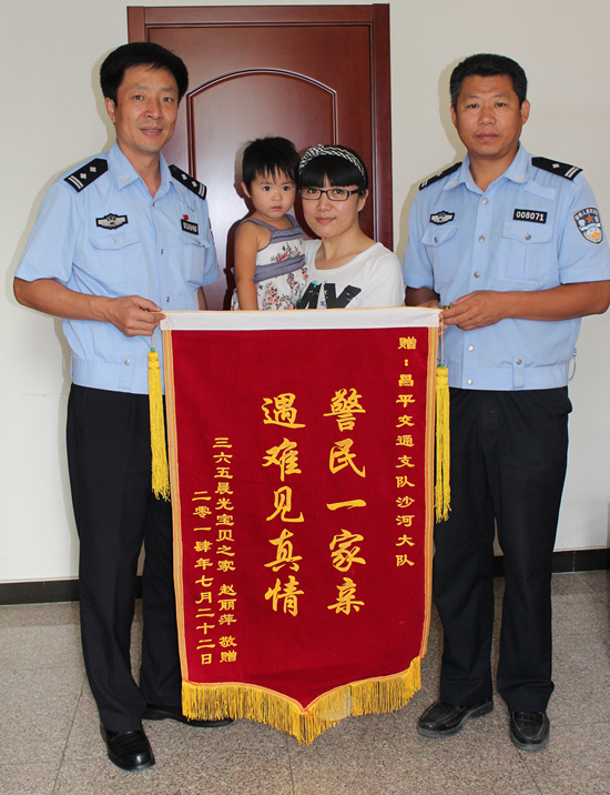 365儿童救助基金主任赵丽萍（右2）向沙河交警刘洪军（右1）赠送锦旗，左1为政委刘玉宝。